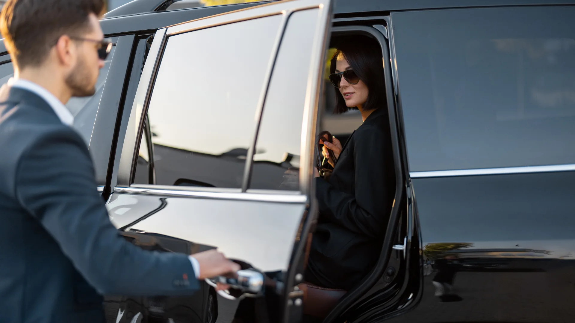 Professional chauffeur opening a black V-Class door in Madrid
