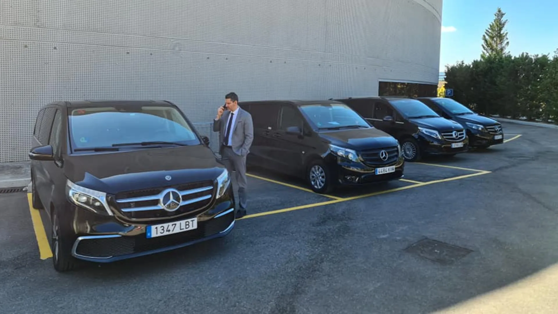 Fleet of black vans lined up for a coordinated group event transfer in Madrid